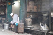 a man in front of a shop adjusting his sandal in Kolkata